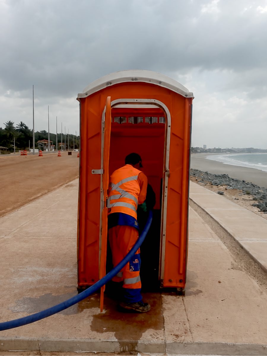 Operador da Ambiban higienizando uma cabine instalada na orla